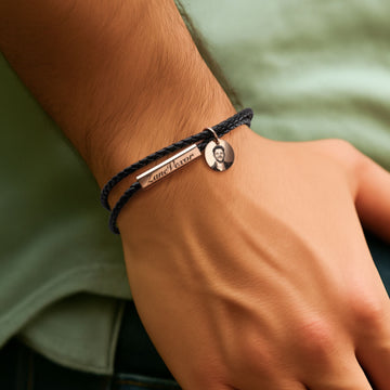 Man trägt das Armband mit Foto- und Textgravur auf dem Anhänger.