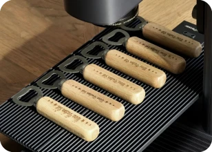 LaserPecker LP2 Plus mit Schiebeerweiterung zum Gravieren von individuellen Logos auf Flaschenöffnern mit Holzgriff als Werbegeschenke.