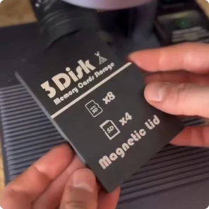 Ein Maker verwendet den LaserPecker LP4, um ein individuelles Logo auf eine schwarze PLA-SD-Box zu gravieren