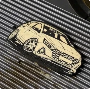 Ein Maker graviert ein detailliertes Auto-Motiv auf einen flexiblen TPU-Schlüsselanhänger
