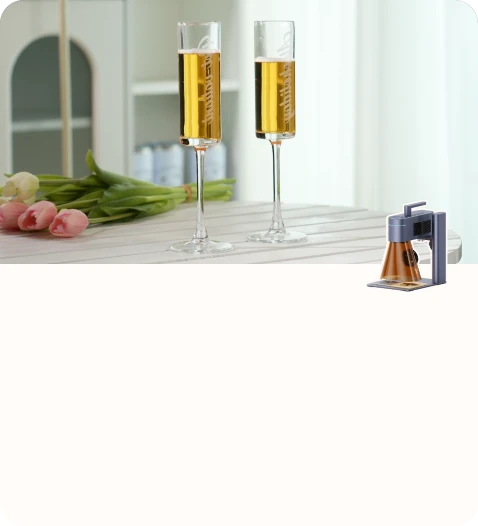 Two champagne glasses engraved with personalized text placed on a table beside a bouquet of tulips.