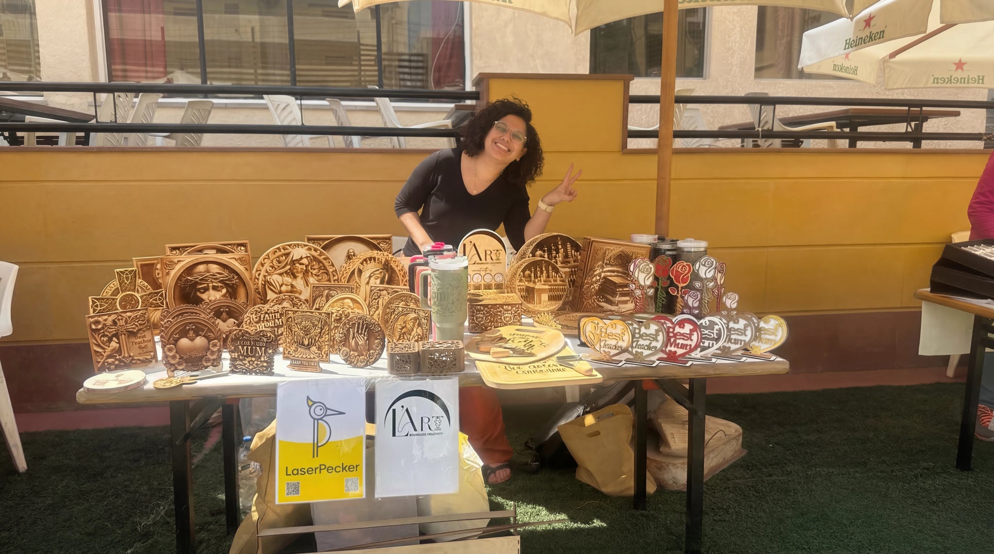 An einem Marktstand werden personalisierte Holzornamente graviert und ausgestellt.