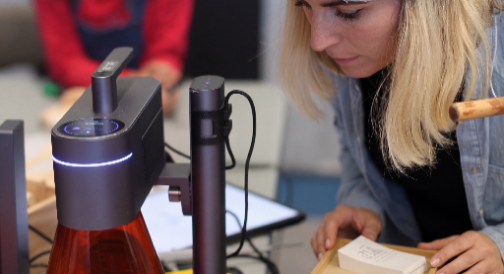 Frau graviert ein Produkt mit einer LaserPecker Maschine.