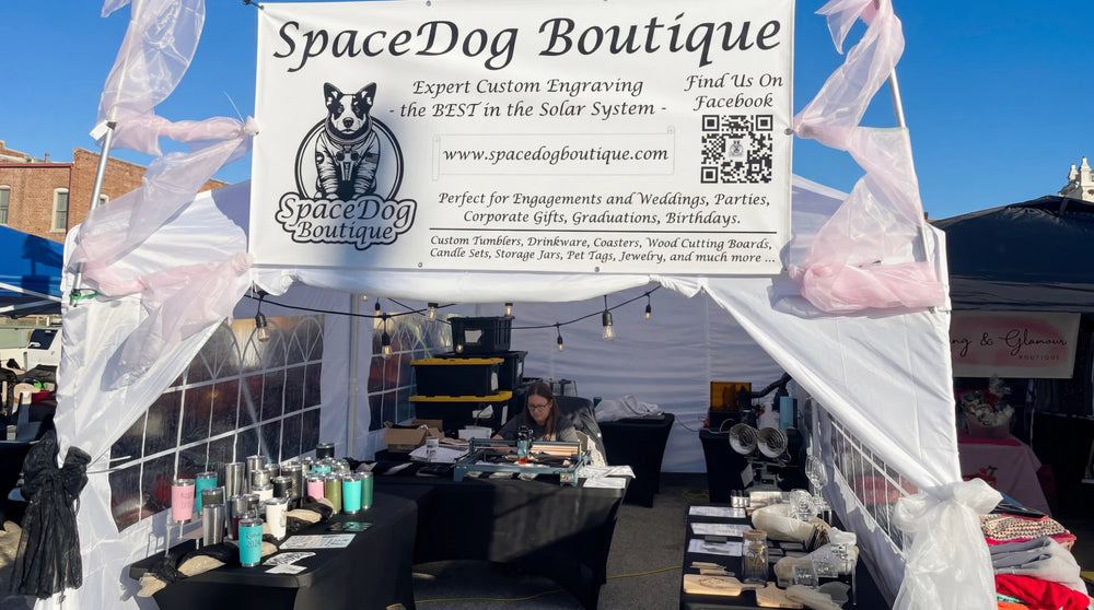 Ein Anbieter stellt gravierte Produkte aus seiner eigenen Designmarke an einem Marktstand vor.