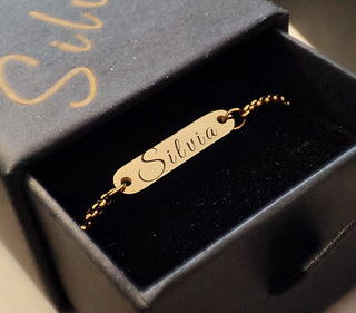 A delicately crafted necklace engraved with a woman’s name using a laser engraving machine, displayed inside a jewelry box.