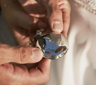 Decorative patterns and text laser engraved onto the metal surface of a pocket watch case.