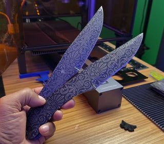 Two knives with intricate decorative engravings covering both the blades and handles.