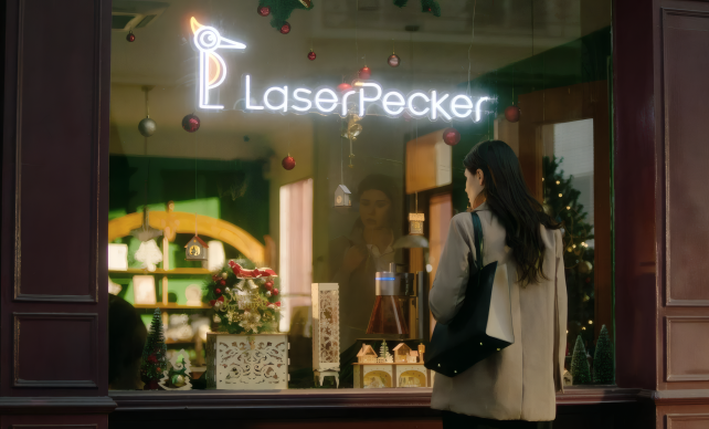 Eine Frau steht vor dem Schaufenster eines LaserPecker-Stores und betrachtet fasziniert die personalisierten gravierten Produkte im Inneren.