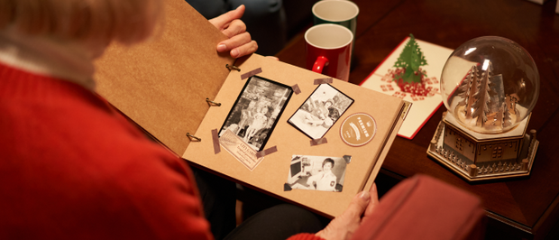 Gemeinsames Betrachten eines handgefertigten Fotoalbums in weihnachtlicher Atmosphäre.