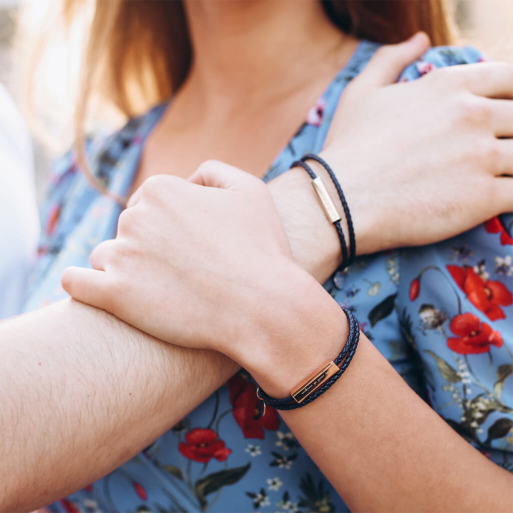 Man und Frau tragen die Lederarmbänder mit Textgravur.